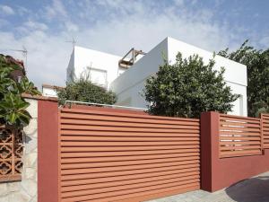 einen Holzzaun vor einem weißen Haus in der Unterkunft Holiday Home in Spain with Pool near Beach in Pineda de Mar