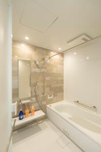 a white bathroom with a tub and a shower at MOVA VILLA Koshi Daiwa 1 in Yuge +32 photos