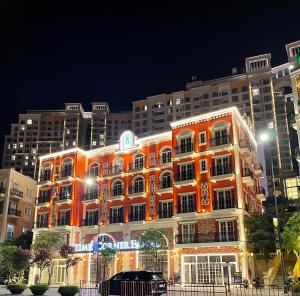 an orange building with christmas lights in front of a building at Times Corner Amalfi Hotel in Phú Quốc