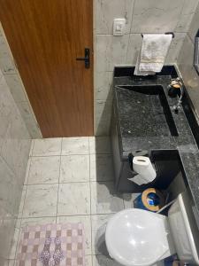 een badkamer met een toilet, een aanrecht en een deur bij Casinha 09 in João Pessoa