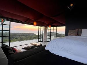 a bedroom with a large bed and a large window at The Castle Uluwatu - Ocean View Luxury villa in Uluwatu
