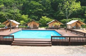 a swimming pool with some tents in the background at Hongcheon Gaon Resort Village Glamping in Hongcheon