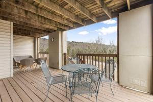 a patio with a table and chairs on a deck at Modern Comfort Retreat in Branson