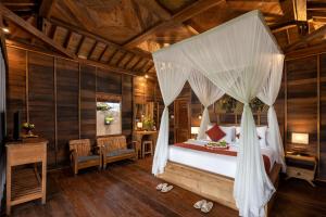 a bedroom with a bed with a canopy at Santris Villas by GenuineHost in Ubud