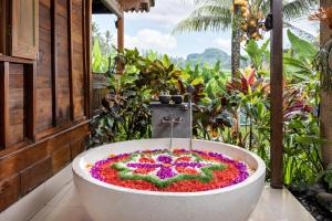 una bañera llena de flores en un jardín en Santris Villas by GenuineHost, en Ubud