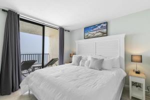 une chambre avec un lit blanc et un balcon dans l'établissement New Listing-Pristine Cozy Ocean Penthouse Condo, à Marco Island