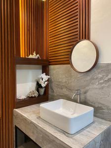 a bathroom with a white sink and a mirror at Evergreen Lodge in Padang +37 photos