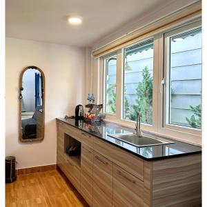 a kitchen with a sink and a mirror at Homestay Đà Lạt - The November Stay in Da Thanh