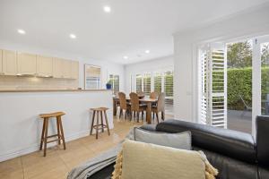 a living room with a couch and a kitchen and a table at Mariner in Rye