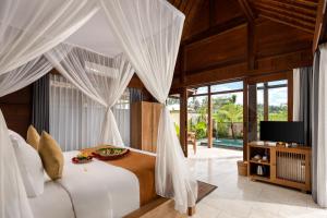 a bedroom with a bed with white drapes at Santris Villas by GenuineHost in Ubud