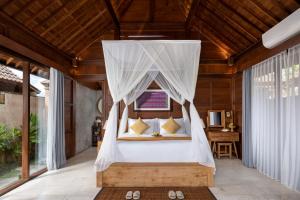 1 dormitorio con cama con dosel en una casa en Santris Villas by GenuineHost, en Ubud
