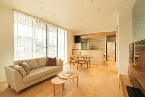 a living room with a couch and a table at Mova Villa Koshi 大和 4 - エレベーター 無料駐車場付 一軒家貸切 in Yuge