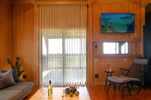 ein Wohnzimmer mit Couch und großem Fenster in der Unterkunft オーシャンビュー BBQ可 最大8名 自然を満喫できる宿 Maru in Motobu