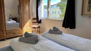 two beds in a room with a mirror and a window at Haus-Kuestenzauber-Laura-und-Sarah in Cuxhaven