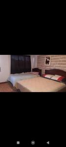 ein Schlafzimmer mit zwei Betten und einer Ziegelwand in der Unterkunft Hostal de Sal Noritha in Uyuni