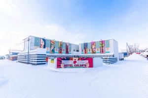 a building with snow on the ground in front of it at Asahikawa Hotel COLOR'S-Adult Only in Asahikawa