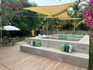 松索纳特Playa Costa azul con piscina y parqueo的泳池边的混凝土长凳上放着枕头