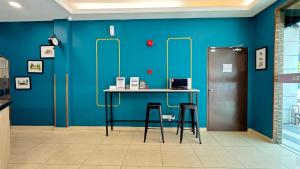 a blue wall with a table and two stools at Best View Hotel Bandar Sunway # Near Sunway Medical-Pyramid-Lagoon in Petaling Jaya