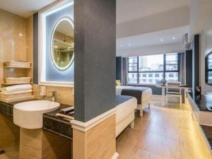 une chambre avec un lit, un lavabo et un miroir dans l'établissement Ming Yang Hotel, à Haikou 139 autres photos