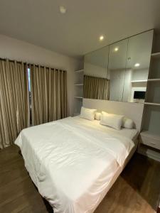 a bedroom with a large white bed with a large mirror at Lee Ardhin by Anggara in Seturan
