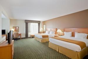 a hotel room with two beds and a flat screen tv at Holiday Inn Express Hotel & Suites Lincoln South by IHG in Lincoln