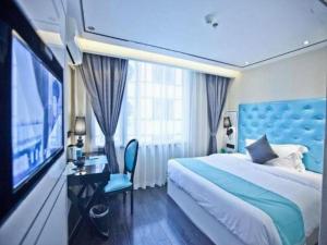 楽山市にあるXana Lite Leshan Haochi Street Branchのベッドとテレビがあるホテルの部屋