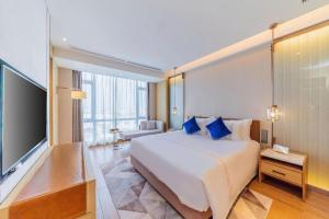 a hotel room with a large bed and a flat screen tv at AUGUSTINE HOTEL in Zhongshan +274 photos