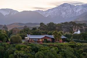 a house in the middle of a forest with mountains at The Entire Mangamaunu Retreat 