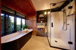 a bathroom with a tub and a sink and a shower at The Entire Mangamaunu Retreat  +100 photos