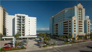 two tall buildings with cars parked in a parking lot at Holiday Sands South in Myrtle Beach