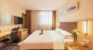 a hotel room with a large bed and a desk at City Comfort Inn Hefei Shuanggang Fuyang Road in Hefei