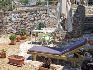 a patio with an umbrella and a table and a bench at White Lotus seaside apartment in Kini
