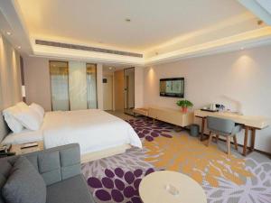 a hotel room with a large bed and a desk at Lavande Hotels· Yueyang Linxiang Zhongfa in Linxiang