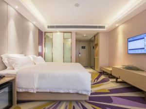a bedroom with a large bed and a flat screen tv at Lavande Hotels· Suizhou Wenfeng in Suizhou +104 photos