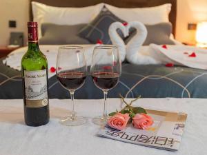 a bottle of wine and two wine glasses on a table at Chonpines Hotel Jining Quanmin Fitness Plaza in Jining