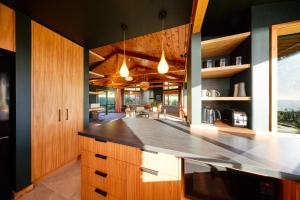 a kitchen with wooden cabinets and a counter top at The Entire Mangamaunu Retreat 