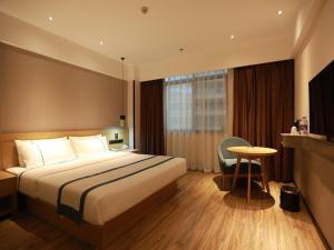 a hotel room with a large bed and a table at City Comfort Inn Qingyuan City Plaza Hefu Dongcheng in Qingyuan +252 photos