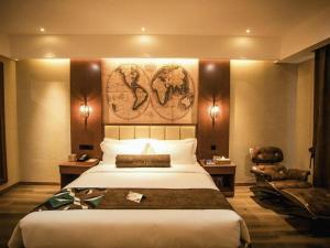 a hotel room with a large bed and a chair at James Joyce Coffetel Xinyang Municipal Government Railway Station in Xinyang +234 photos