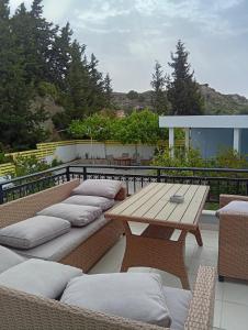 a patio with a wooden table and cushioned benches at Seascape Village in Kalithies