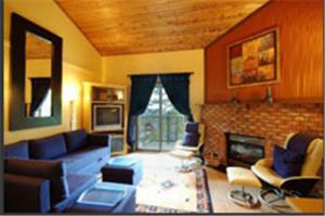 a living room with a couch and a fireplace at Innwest Kirkwood Inn in Kimberley