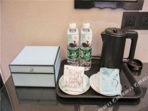 - un plateau/bouilloire et des tasses sur une table dans l'établissement Xana Hotelle Rizhao Lanshan District Government, à Lanshantou