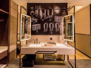 a bathroom with a sink and a mirror at ZMAX Hotel Yan'an Baimi Avenue Baotashan in Qiao'ergou +104 photos
