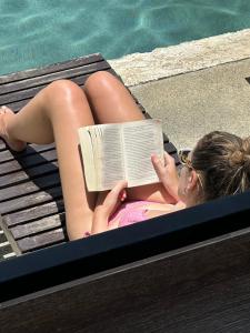 a woman laying on a raft reading a book by a pool at Samui Backpacker Hotel in Bangrak Beach +51 photos