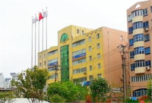un edificio amarillo con banderas delante en 7Days Inn Changshou Road Subway station, en Shanghái