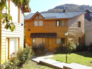 a wooden house with a yellow door at Las Cuatro Estaciones in San Martín de los Andes