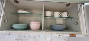 a cupboard with plates and bowls and dishes in it at Marine City Cozy Stay in Busan +29 photos