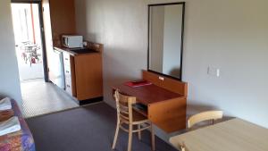 a kitchen with a dining room table and chairs at Herbert Valley Motel in Ingham