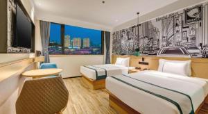 a hotel room with two beds and a window at City Comfort Inn Tangshan Railway Station Lunan District Government in Tangshan