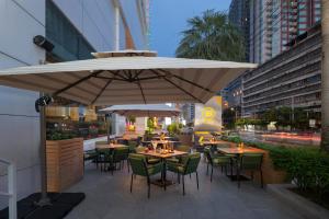 a restaurant with tables and chairs under a large umbrella at The Berkeley Hotel Pratunam in Bangkok