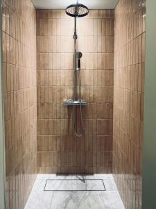 a shower with a shower head in a tiled bathroom at Historic Apartment At Karljohansvern In Horten in Horten
